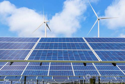 多晶硅太阳能电池板和风力涡轮机在混合动力发电厂系统中发电,站在